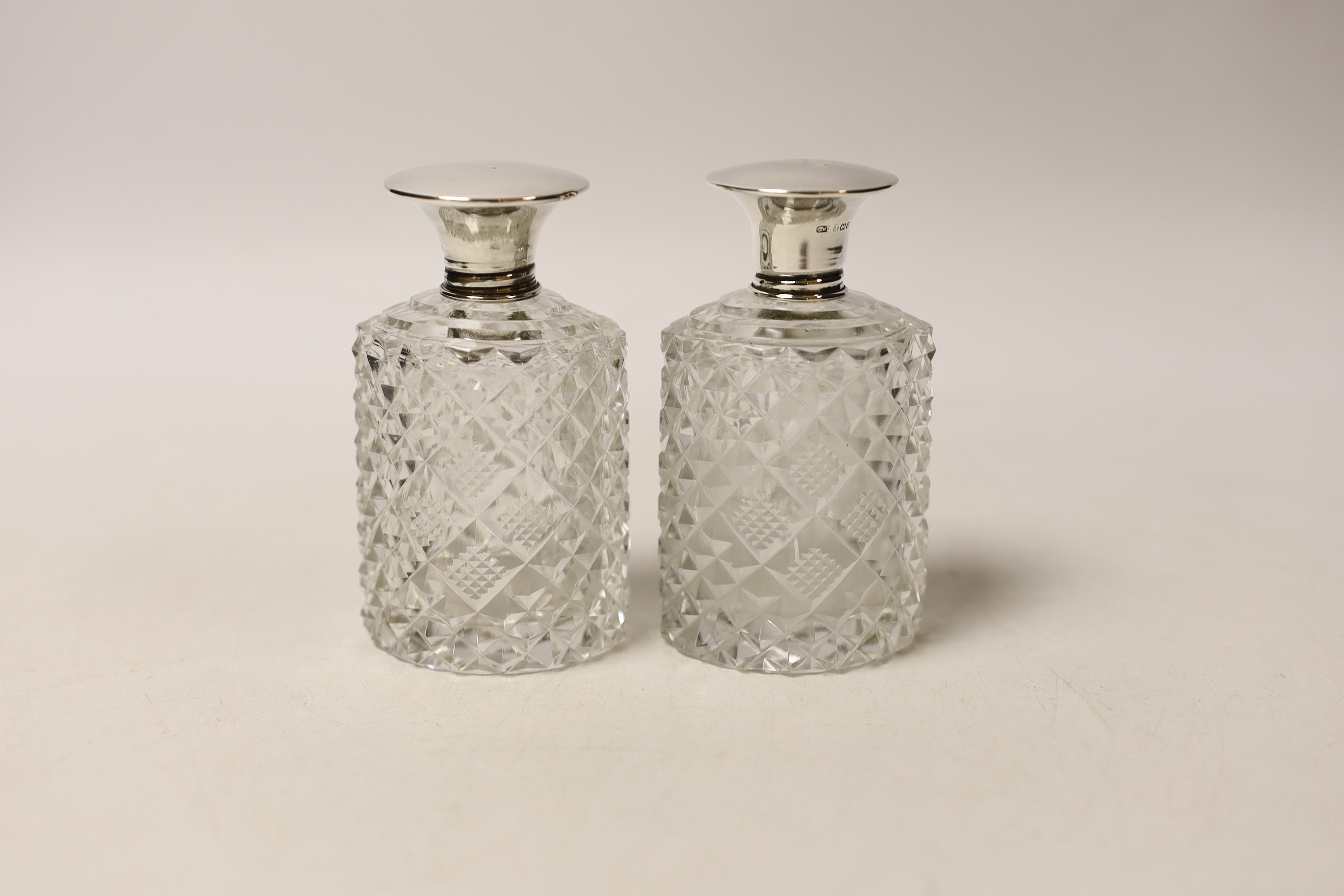 A George V silver and tortoiseshell pique mounted dressing table set, Adie Bros, Birmingham, 1934, and three silver topped toilet jars.
